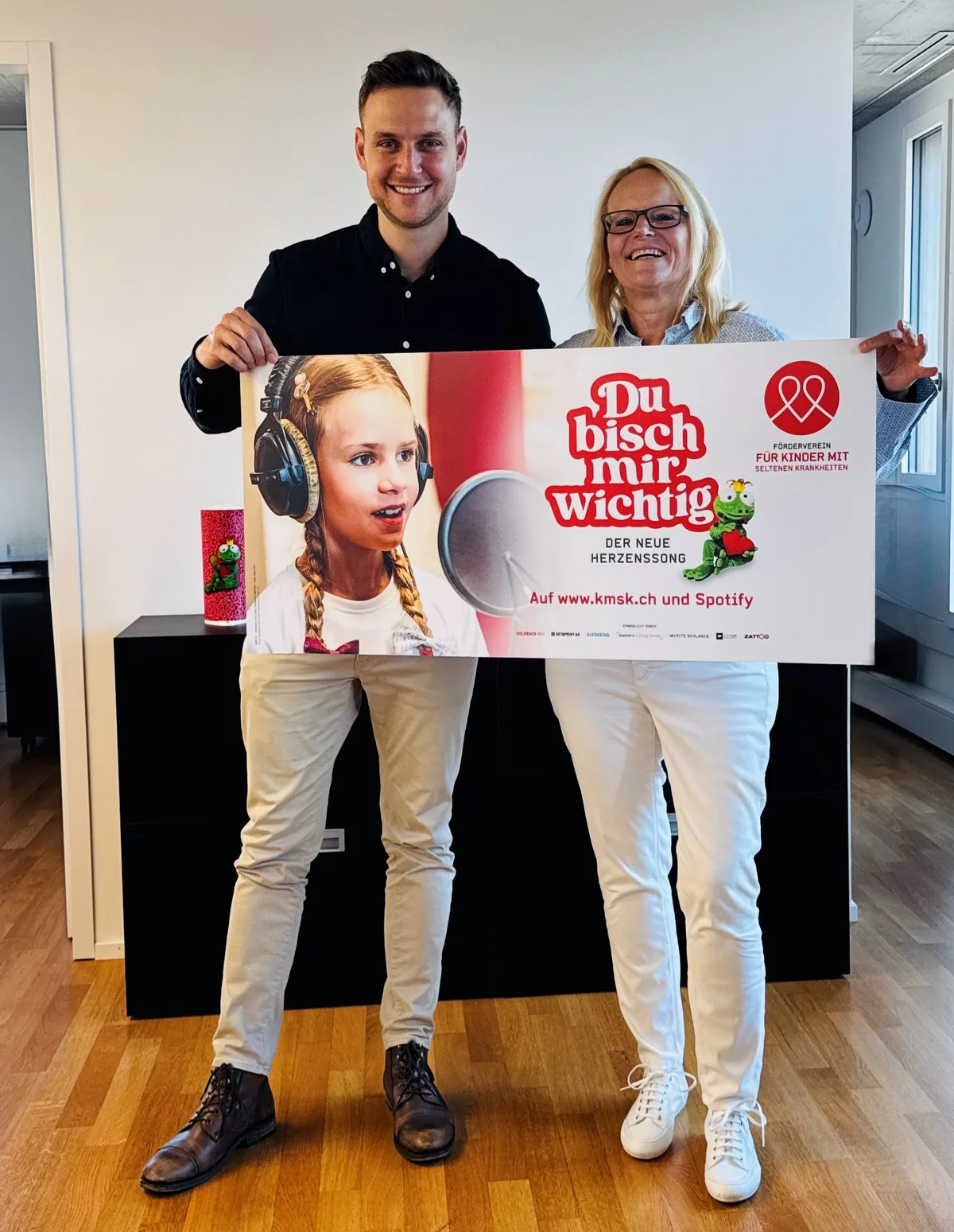 Moritz Schlanke und Manuela Stier halten gemeinsam ein Banner mit der Aufschrift «Du bisch mir wichtig» in den Händen.